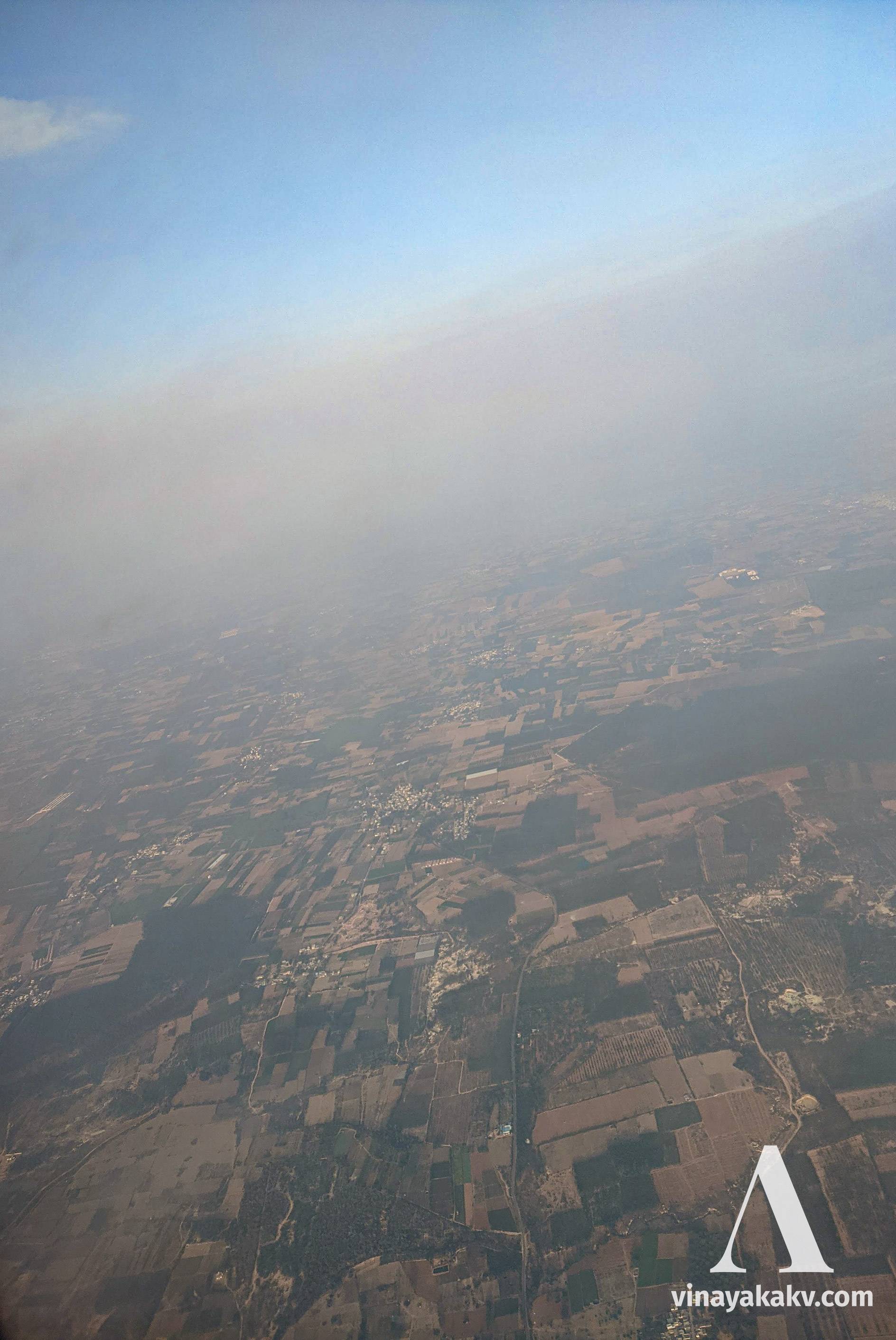 View from an airplane reaching upper haze layer during its ascent. The haze line can be seen as a brownish line at the top, with clear sky above.